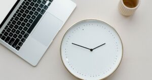 Laptop and clock on desk. how long does it take for a website to show in google