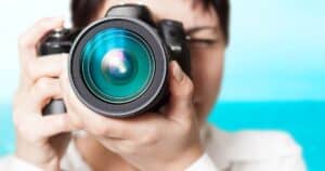 Person holding a camera up to their face, focusing on taking a picture