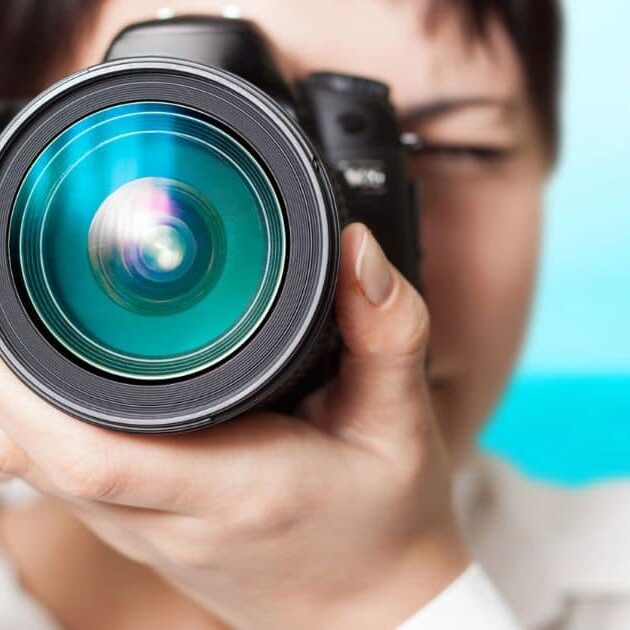 Person holding a camera up to their face, focusing on taking a picture