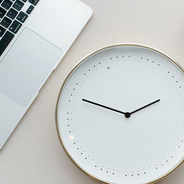 Laptop and clock on desk. how long does it take for a website to show in google